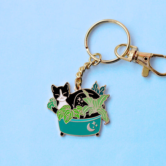 Porte-clés émail doré Glitter Punk, chat noir faisant la sieste au cœur de plantes vertes