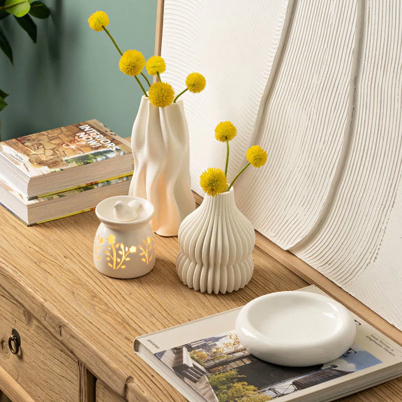 Brûle-parfum en céramique blanche ajourée à motifs floraux surmonté d'un oiseau décoratif