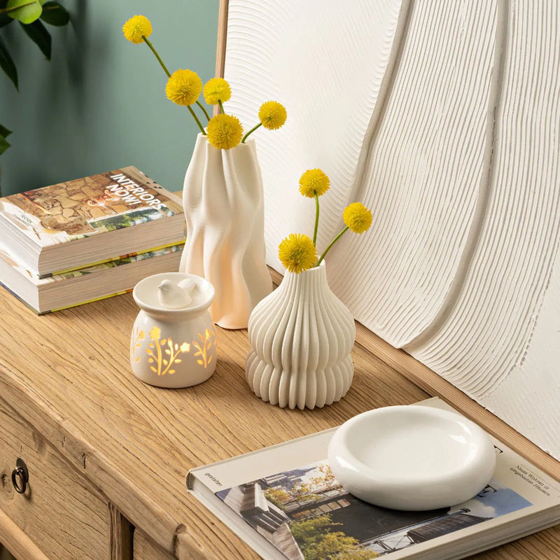 Brûle-parfum en céramique blanche ajourée à motifs floraux surmonté d'un oiseau décoratif