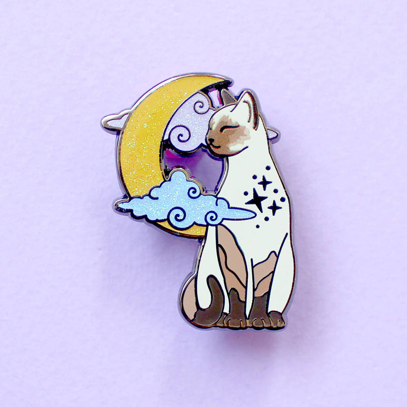 Pin's Glitter Punk chat siamois assis devant une lune scintillante et des nuages pastel