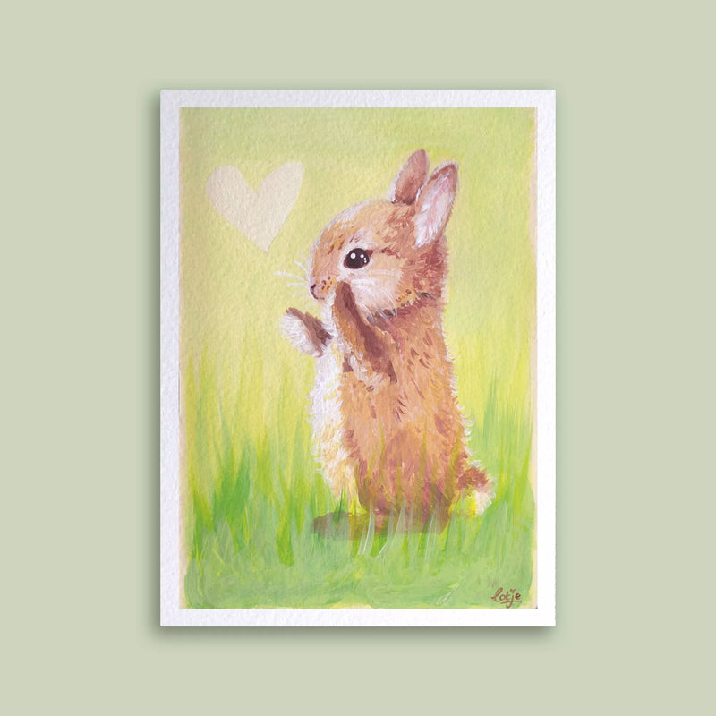 Carte postale petit lapin brun debout dans l'herbe à côté d'un cœur peint