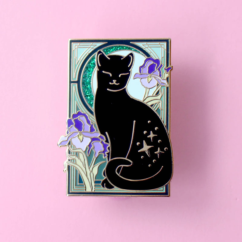 Pin's Glitter Punk Art Nouveau chat noir étoilé entouré de fleurs d'iris violettes sur fond vert