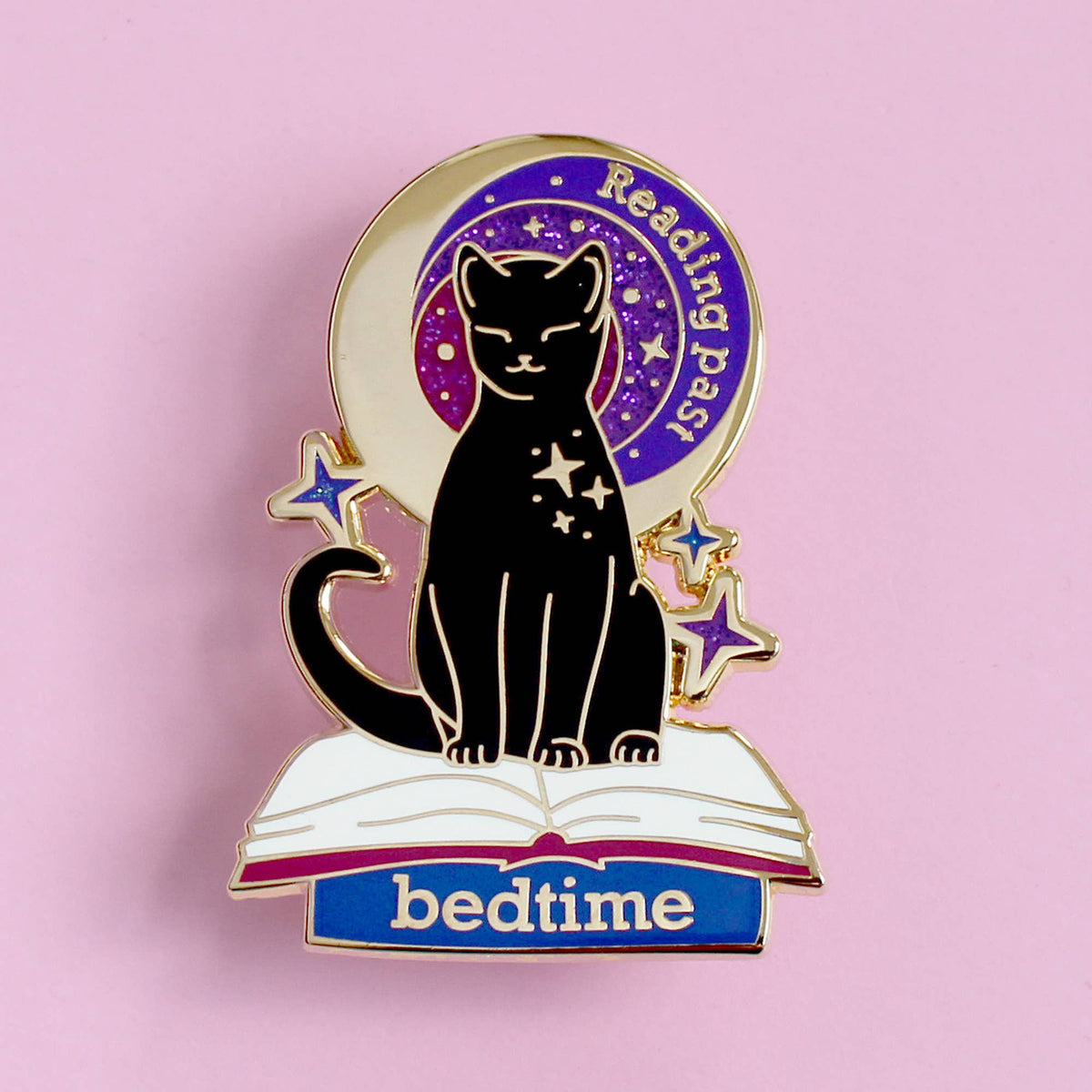 Pin's Glitter Punk Reading past bedtime, chat noir assis sur un livre ouvert sous un ciel étoilé