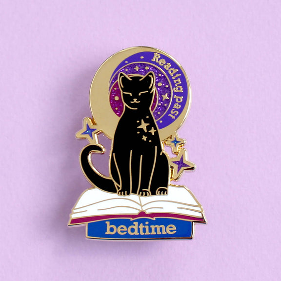 Pin's Glitter Punk Reading past bedtime, chat noir assis sur un livre ouvert sous un ciel étoilé