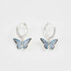 Boucles d'oreilles huggie plaqué argent Fable England, charm papillon bleu émaillé à la main