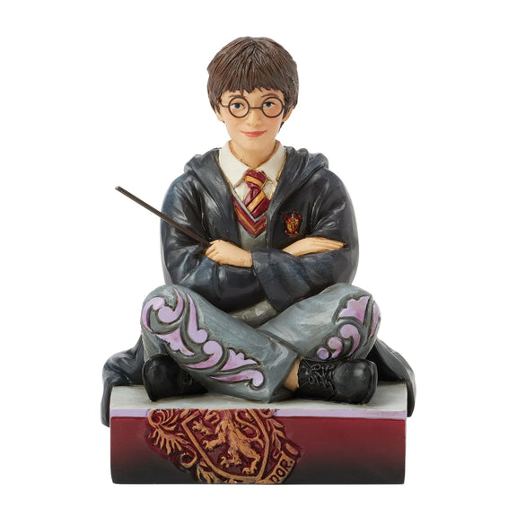 Figurine Harry Potter by Jim Shore, Harry assis par terre en robe de Poudlard tenant sa baguette