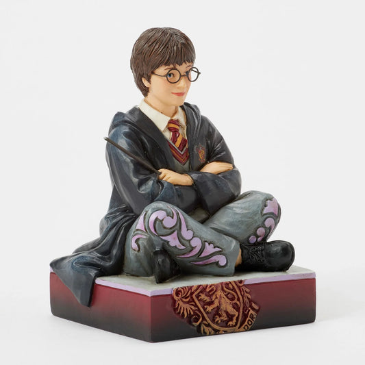 Figurine Harry Potter by Jim Shore, Harry assis par terre en robe de Poudlard tenant sa baguette