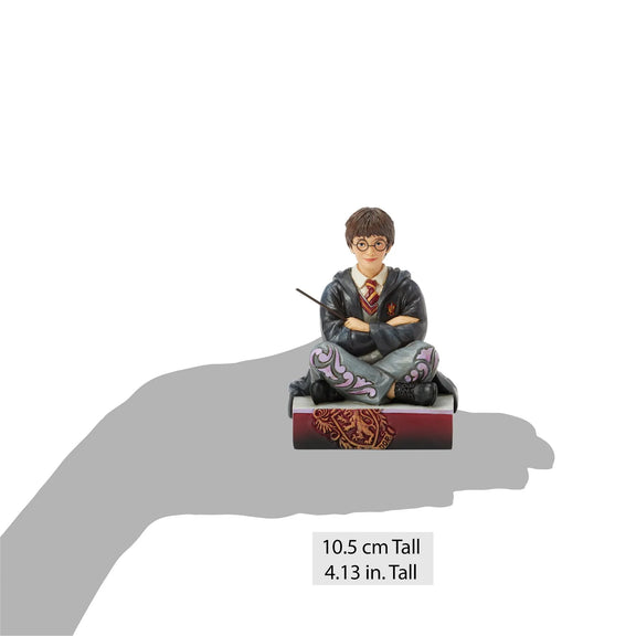 Figurine Harry Potter by Jim Shore, Harry assis par terre en robe de Poudlard tenant sa baguette