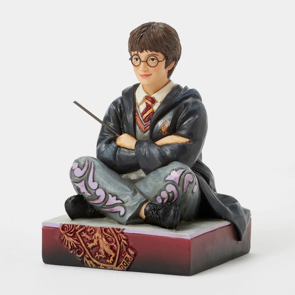 Figurine Harry Potter by Jim Shore, Harry assis par terre en robe de Poudlard tenant sa baguette