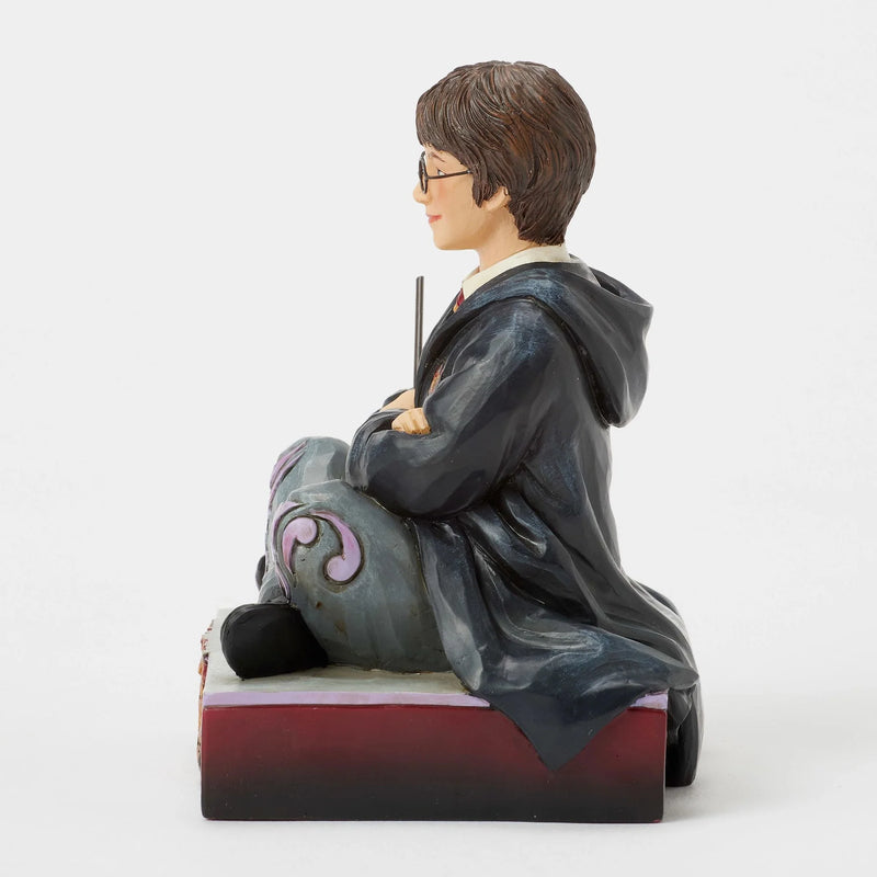 Figurine Harry Potter by Jim Shore, Harry assis par terre en robe de Poudlard tenant sa baguette
