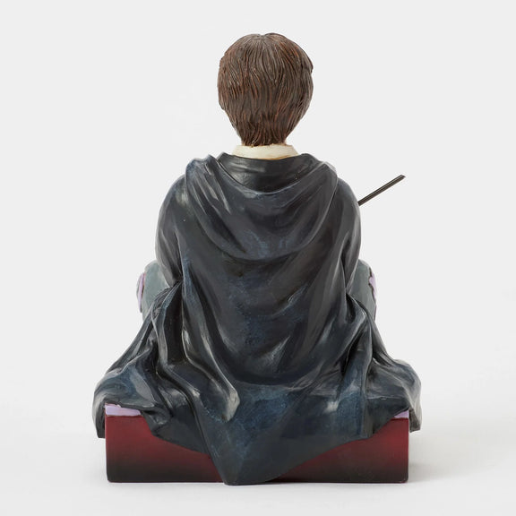 Figurine Harry Potter by Jim Shore, Harry assis par terre en robe de Poudlard tenant sa baguette