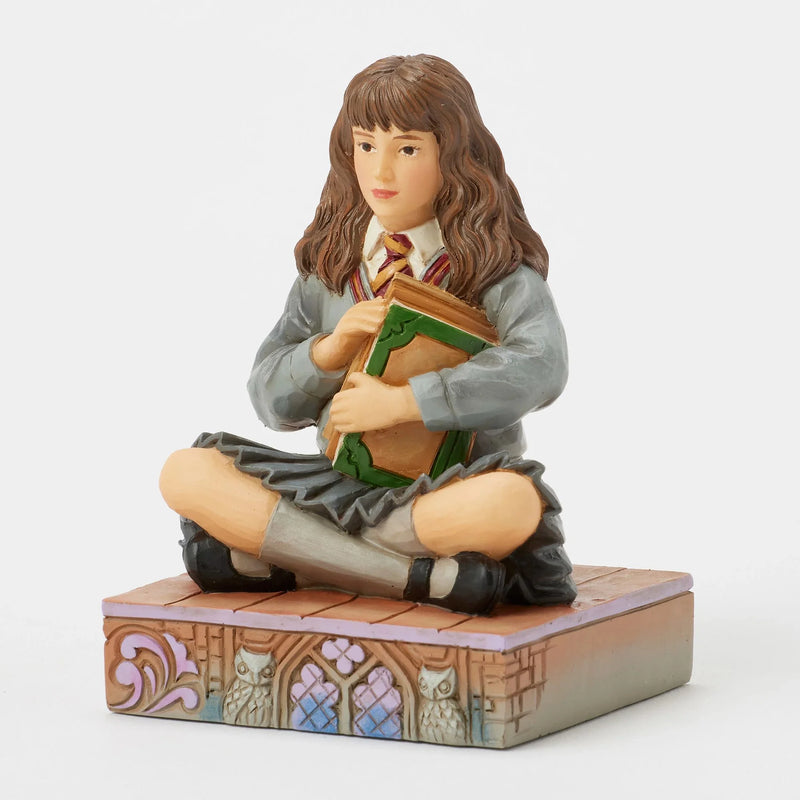 Figurine Harry Potter by Jim Shore, Hermione Granger assise serrant ses livres contre elle