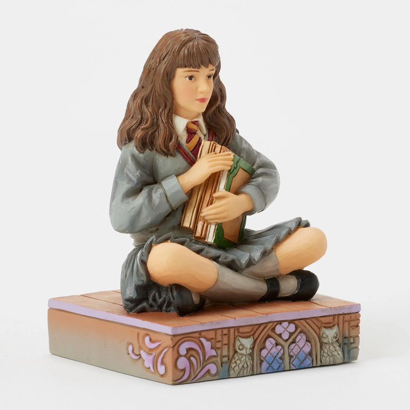 Figurine Harry Potter by Jim Shore, Hermione Granger assise serrant ses livres contre elle