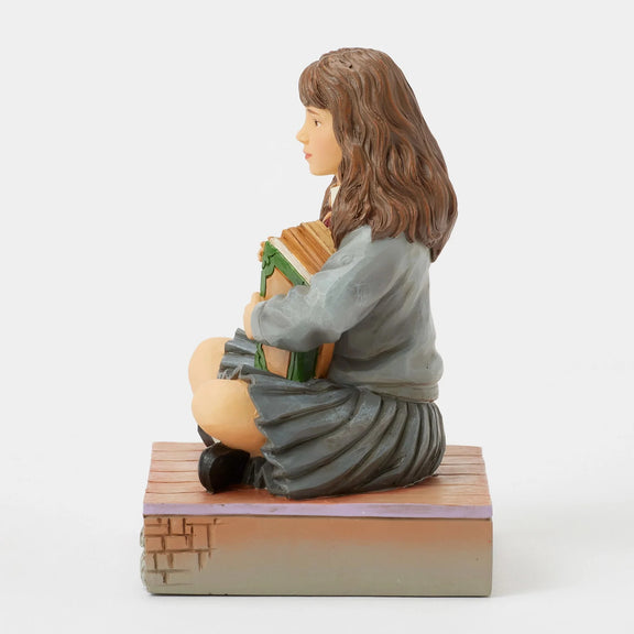 Figurine Harry Potter by Jim Shore, Hermione Granger assise serrant ses livres contre elle