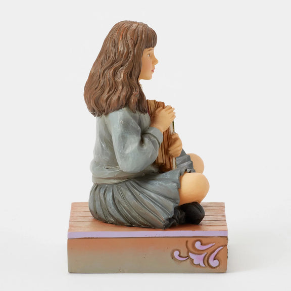 Figurine Harry Potter by Jim Shore, Hermione Granger assise serrant ses livres contre elle