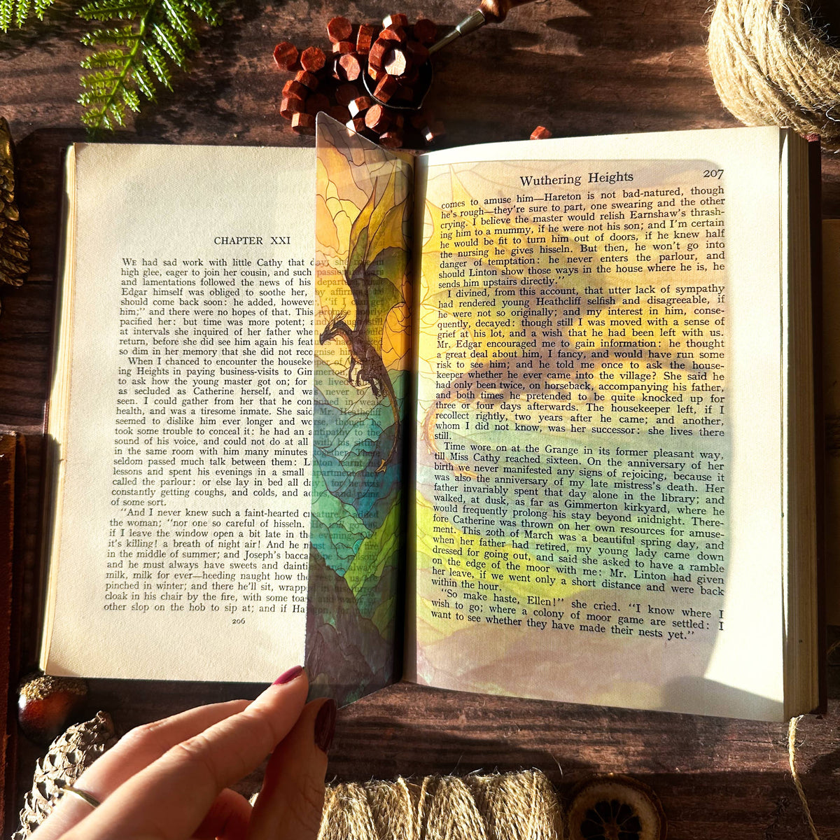 Marque-page transparent effet vitrail avec un dragon dominant un paysage montagneux