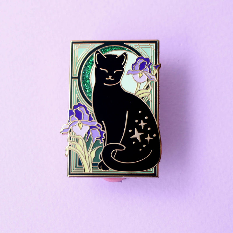 Pin's Glitter Punk Art Nouveau chat noir étoilé entouré de fleurs d'iris violettes sur fond vert