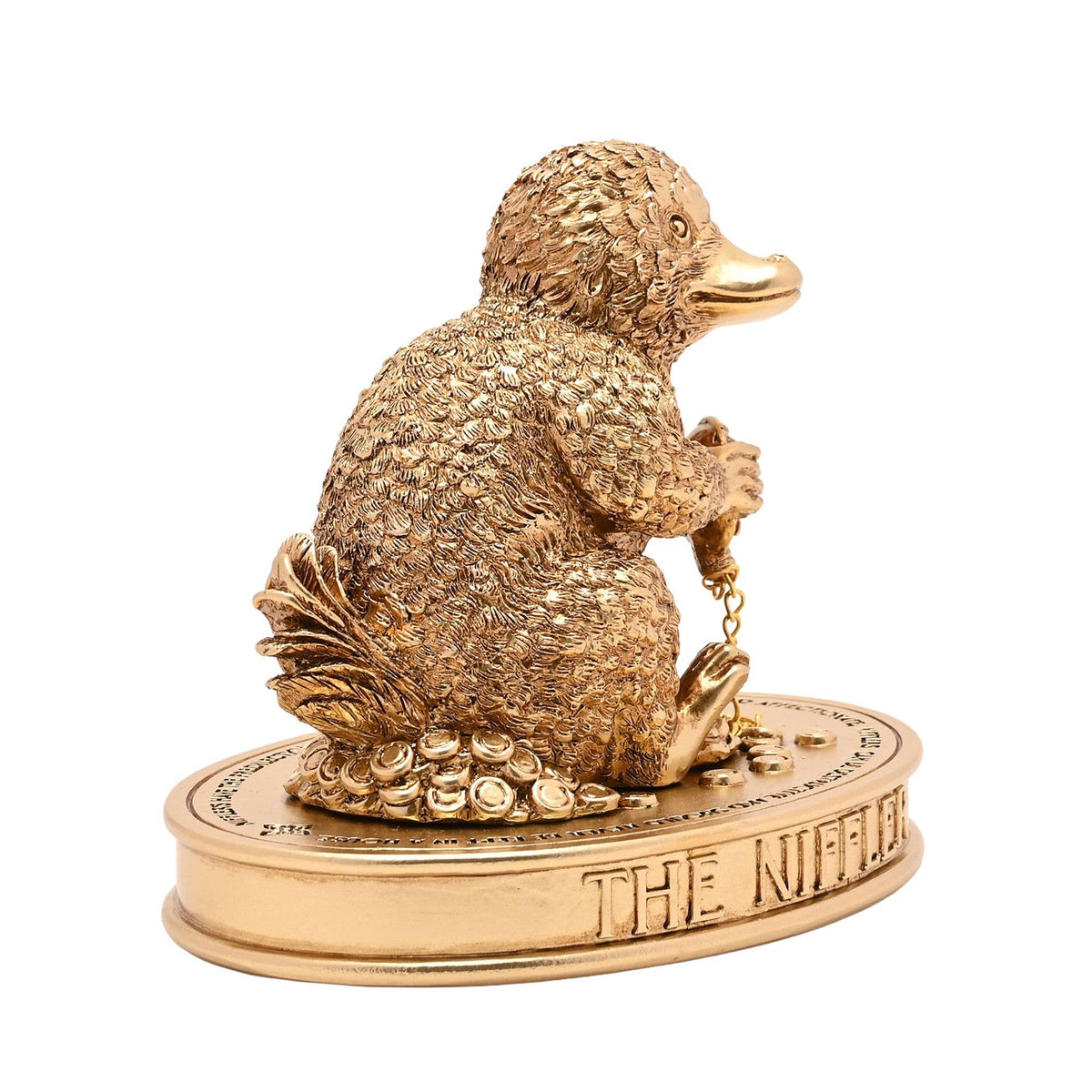 Figurine Harry Potter du Niffleur serrant une chaîne dorée sur un socle parsemé de trésors
