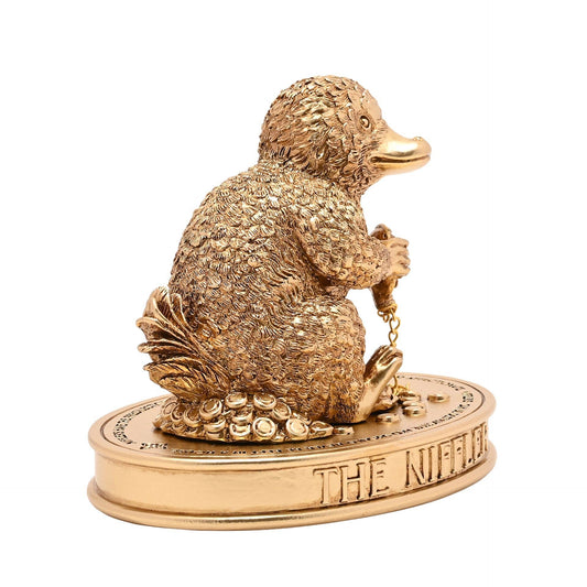 Figurine Harry Potter du Niffleur serrant une chaîne dorée sur un socle parsemé de trésors