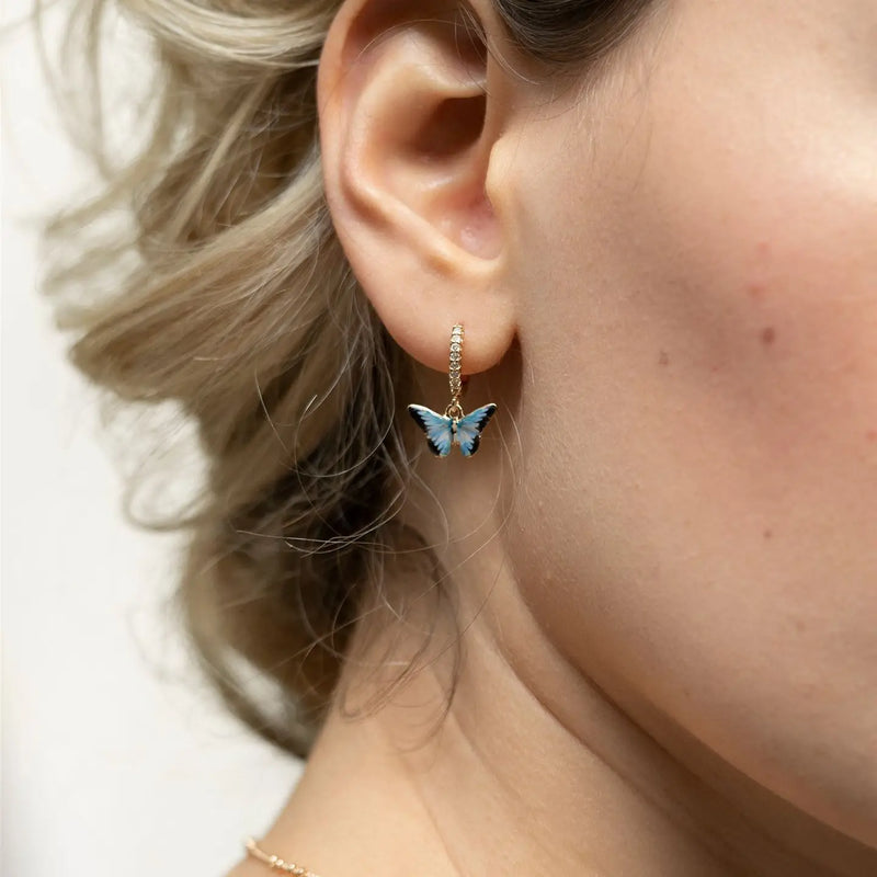 Boucles d'oreilles huggie plaqué argent Fable England, charm papillon bleu émaillé à la main