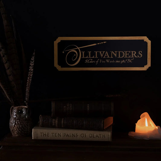 Enseigne murale Harry Potter Ollivanders en métal noir avec bordure dorée en bois
