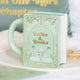 Mug en céramique en forme de livre vert pastel Coffee & Books avec motifs floraux et cygnes dorés