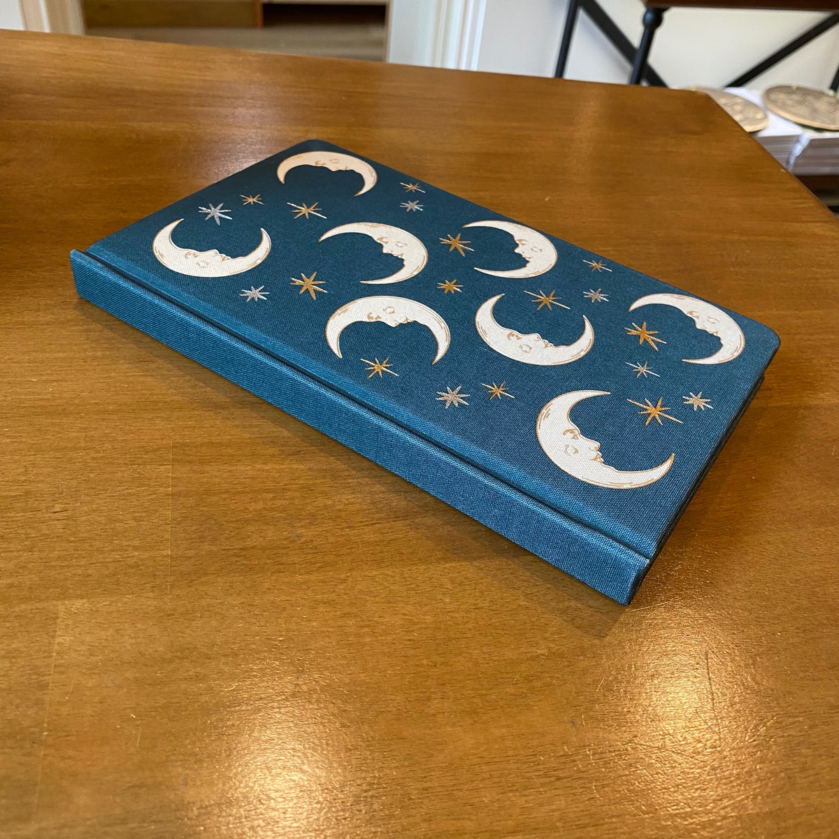 Carnet relié Designworks Ink à couverture en tissu bleu profond ornée de lunes et d'étoiles dorées