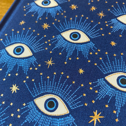 Carnet relié Designworks Ink Starry Eyed, couverture tissu bleu profond aux yeux mystiques dorés