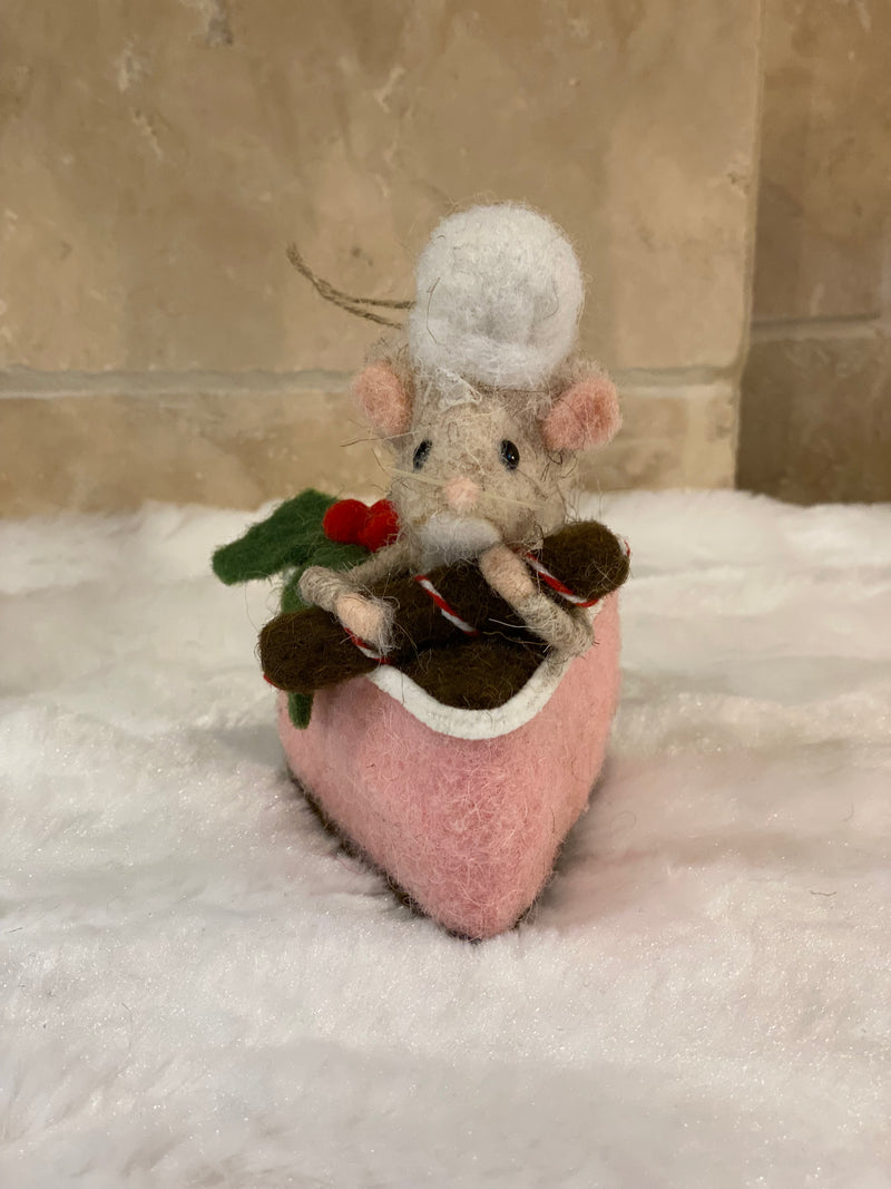 Souris pâtissière en laine feutrée à suspendre, posée sur une part de gâteau rose avec houx