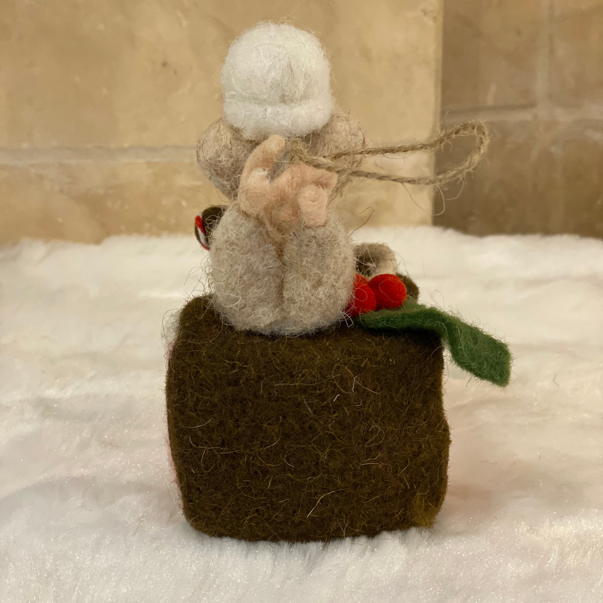 Souris pâtissière en laine feutrée à suspendre, posée sur une part de gâteau rose avec houx