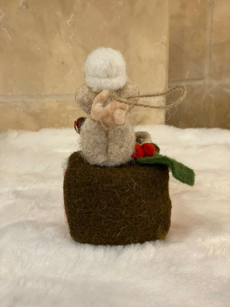 Souris pâtissière en laine feutrée à suspendre, posée sur une part de gâteau rose avec houx