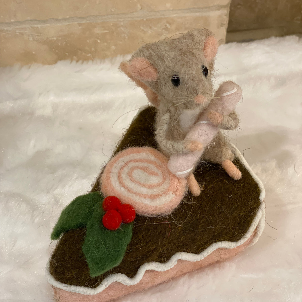 Figurine de Noël en laine feutrée, souris assise sur une part de gâteau avec houx et glaçage