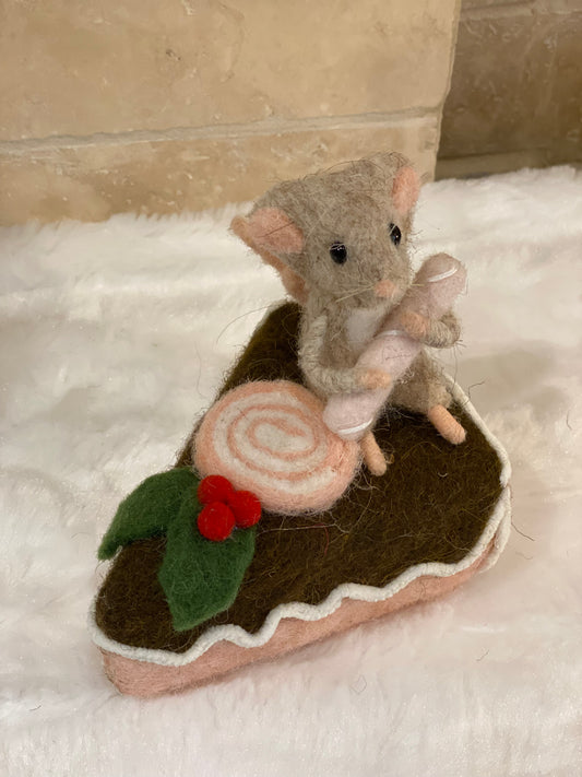 Figurine de Noël en laine feutrée, souris assise sur une part de gâteau avec houx et glaçage