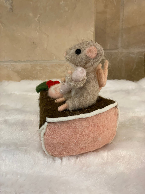 Figurine de Noël en laine feutrée, souris assise sur une part de gâteau avec houx et glaçage