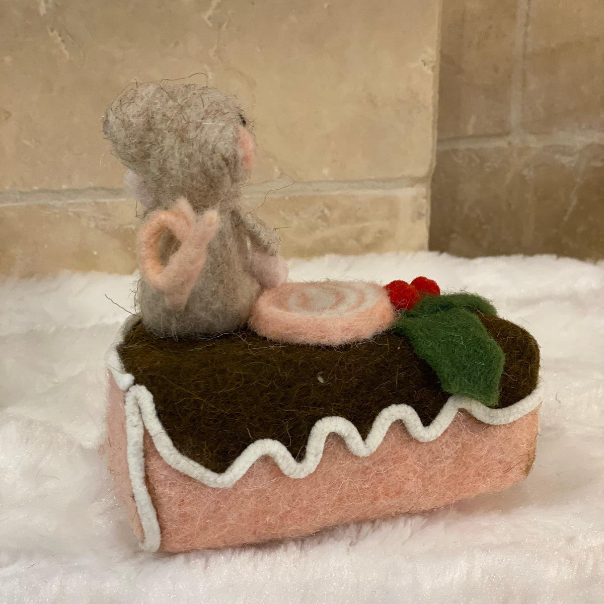 Figurine de Noël en laine feutrée, souris assise sur une part de gâteau avec houx et glaçage