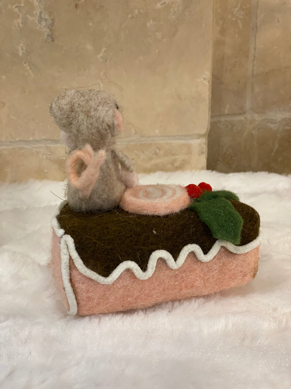 Figurine de Noël en laine feutrée, souris assise sur une part de gâteau avec houx et glaçage