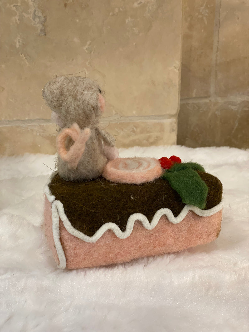 Figurine de Noël en laine feutrée, souris assise sur une part de gâteau avec houx et glaçage