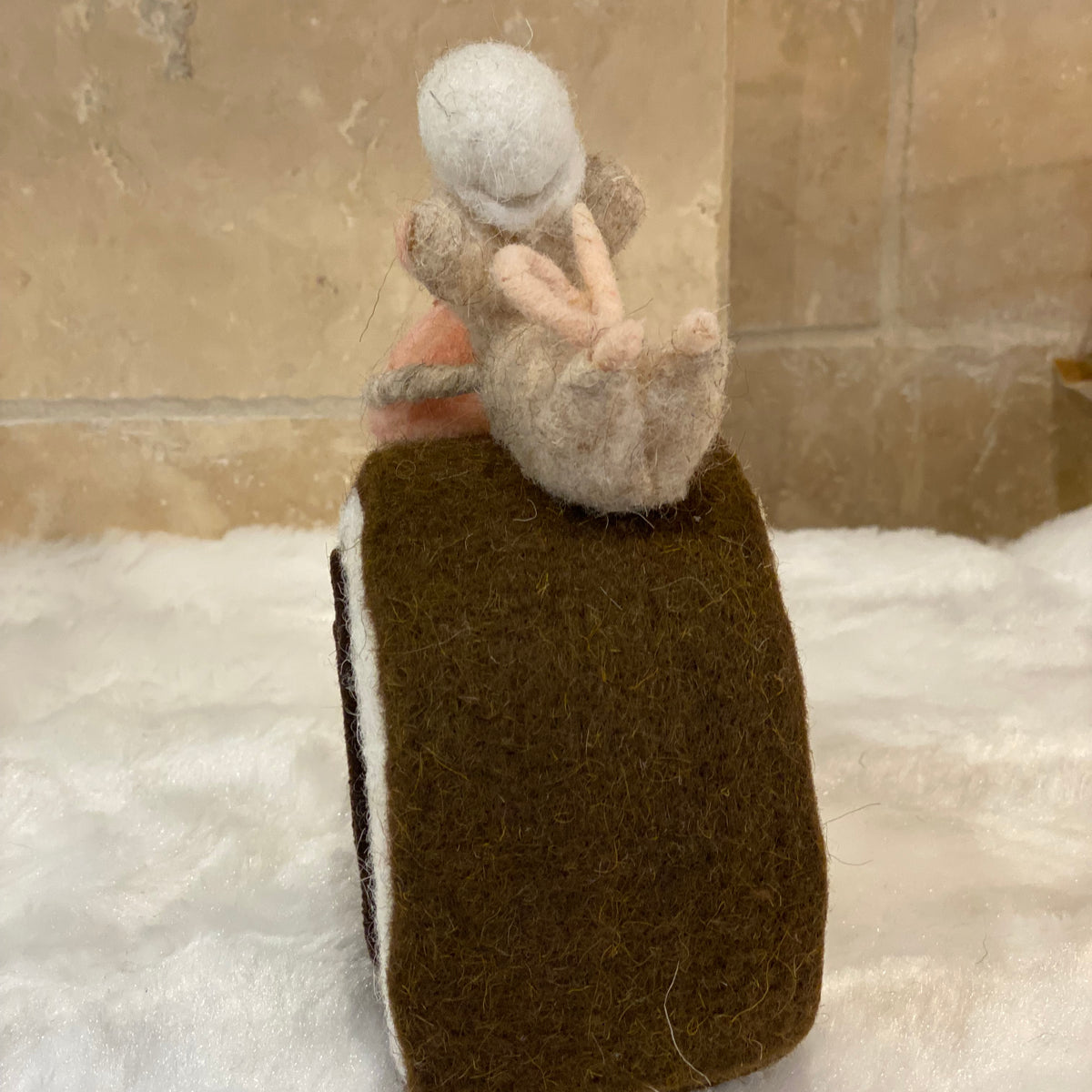 Figurine de Noël en laine feutrée, souris à toque blanche assise sur une bûche pâtissière