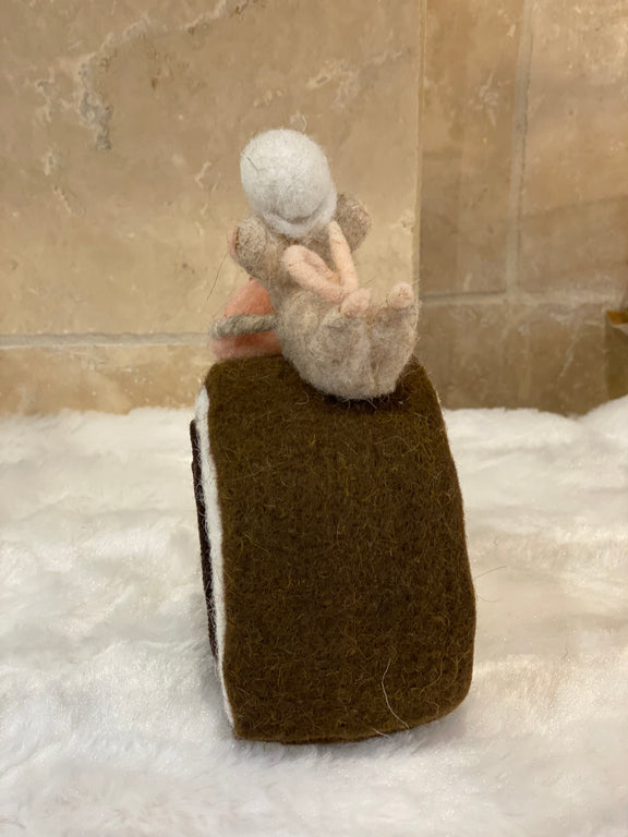 Figurine de Noël en laine feutrée, souris à toque blanche assise sur une bûche pâtissière