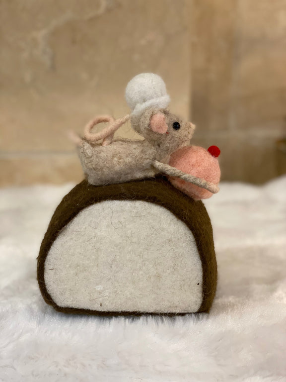 Figurine de Noël en laine feutrée, souris à toque blanche assise sur une bûche pâtissière