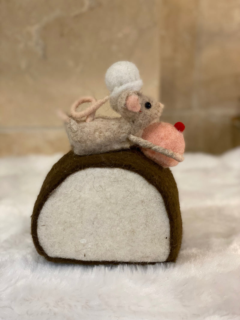 Figurine de Noël en laine feutrée, souris à toque blanche assise sur une bûche pâtissière