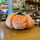 Peluche citrouille orange Bukowski de 25 cm avec sourire brodé et feuilles en tissu vert