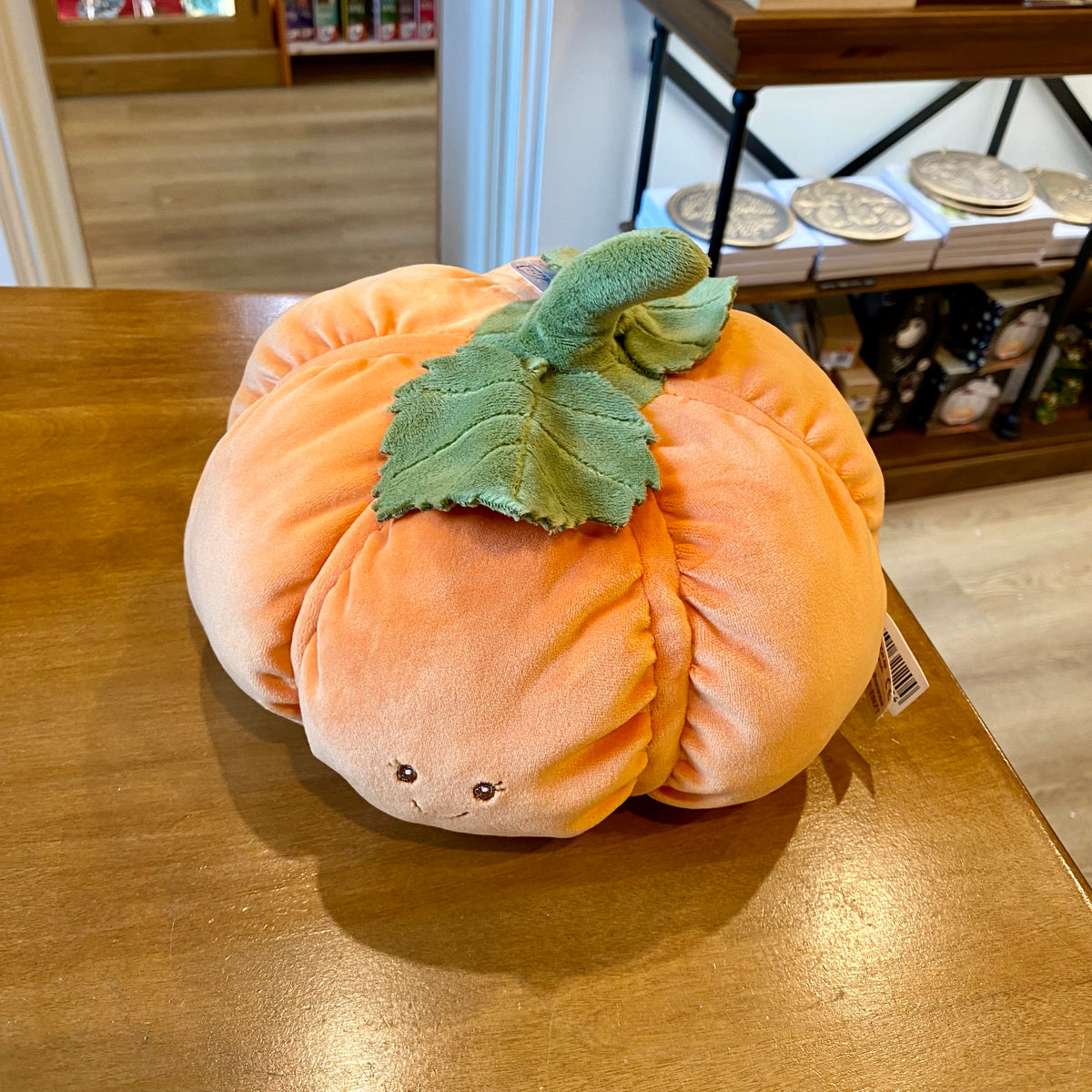 Peluche citrouille orange Bukowski de 25 cm avec sourire brodé et feuilles en tissu vert