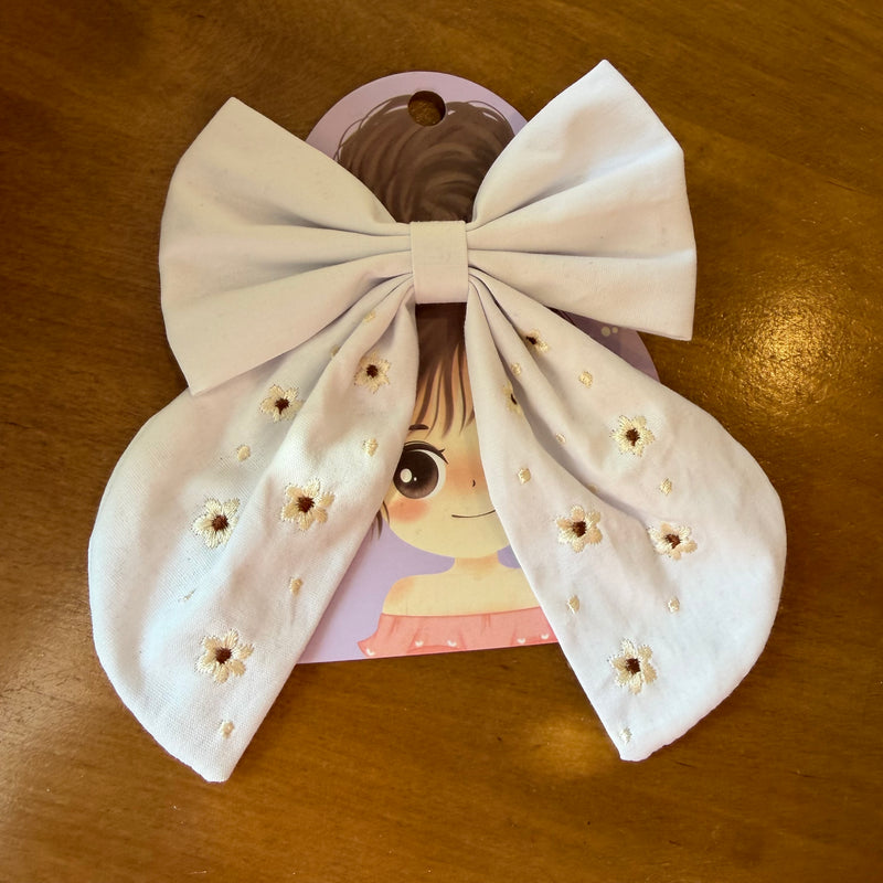 Pince à cheveux nœud en tissu blanc lumineux ornée de petites broderies florales ton sur ton