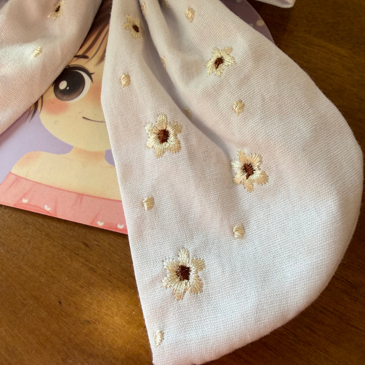 Pince à cheveux nœud en tissu blanc lumineux ornée de petites broderies florales ton sur ton