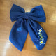 Pince à cheveux nœud en tissu bleu profond décorée de petites fleurs brodées multicolores
