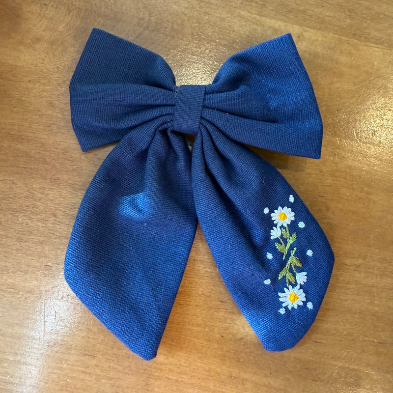 Pince à cheveux nœud en tissu bleu profond décorée de petites fleurs brodées multicolores