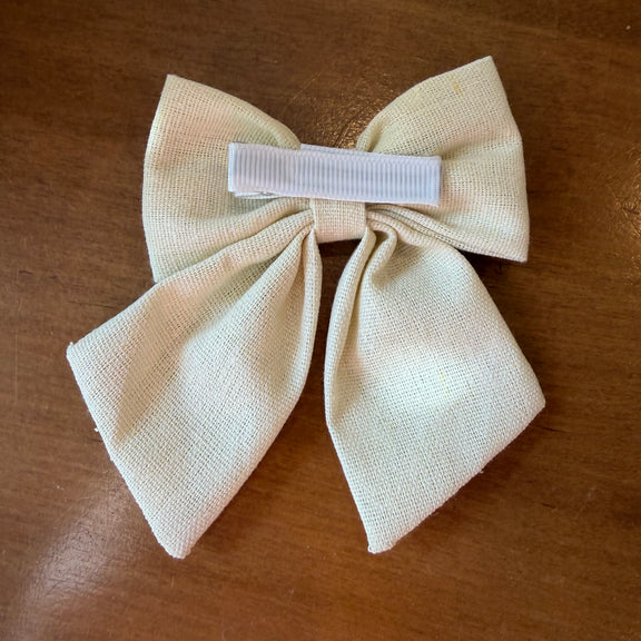 Pince à cheveux nœud en tissu écru texturé brodé d'un tournesol jaune, format compact