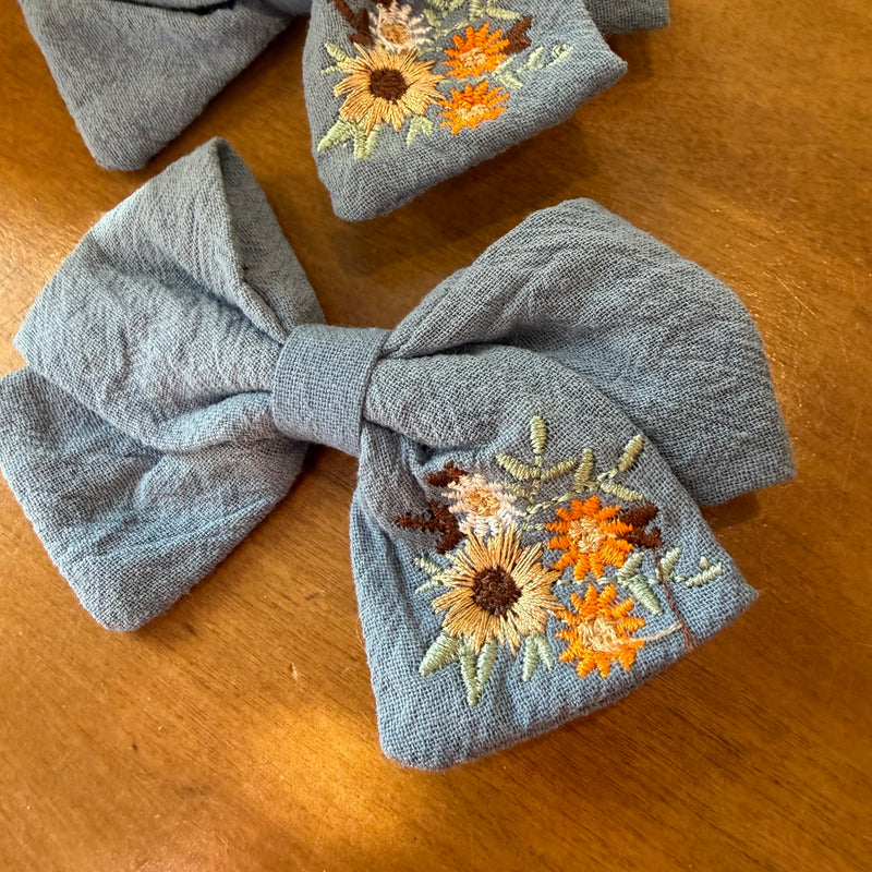 Lot de deux pinces à cheveux nœud en tissu bleu texturé ornées de broderies florales colorées