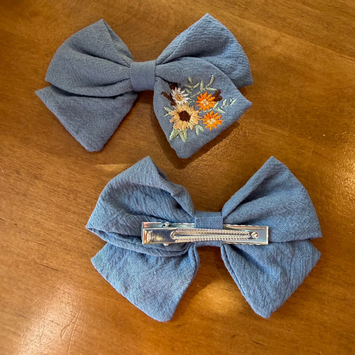 Lot de deux pinces à cheveux nœud en tissu bleu texturé ornées de broderies florales colorées
